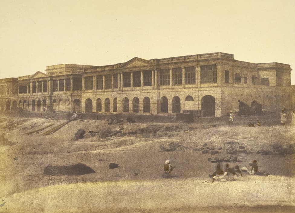 Beach of Madras, c.1851. A hand-coloured salt print showing colonial buildings on the foreshore at Madras with the Bay of Bengal stretching beyond.