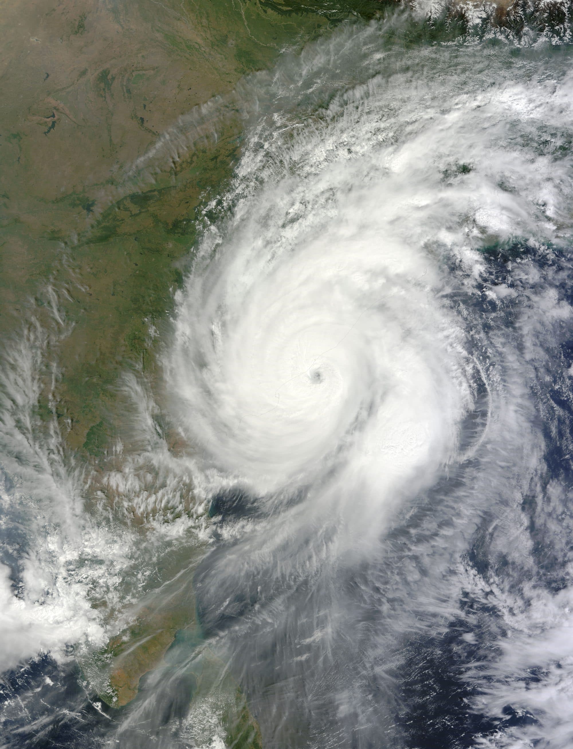 A satellite image of Cyclone Hudhud on 12 October 2014: a tight white spiral of cloud with a clear eye, centred on the north Andhra coast, with the Bay of Bengal below it.